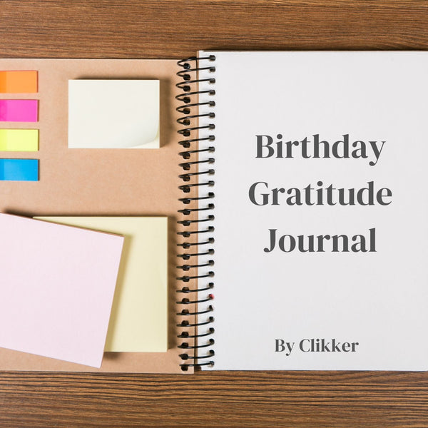 Birthday Gratitude Journal by Clikker on a wooden surface with colorful sticky notes.